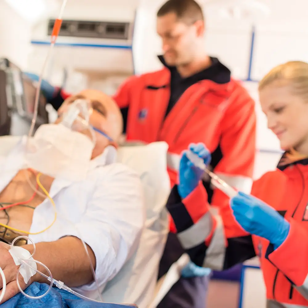 Patient in ambulance receiving medical care from paramedics